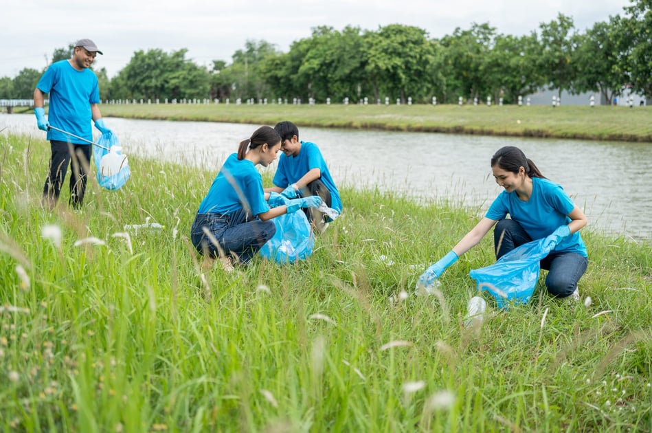 Volunteers in high-visibility vests clearing litter in a park