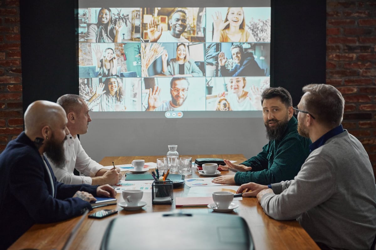 Team in a meeting room on a video call with colleagues in other countries