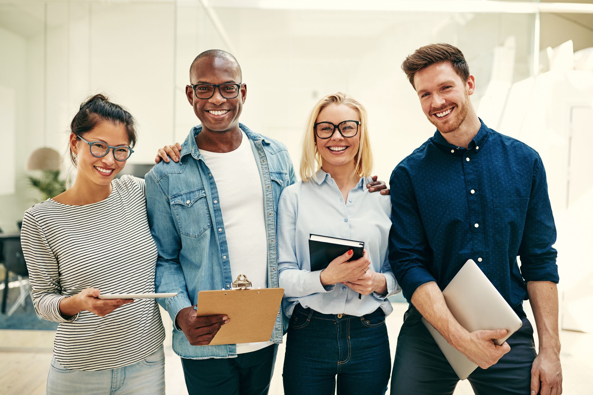 A group of colleagues standing together in a bright office