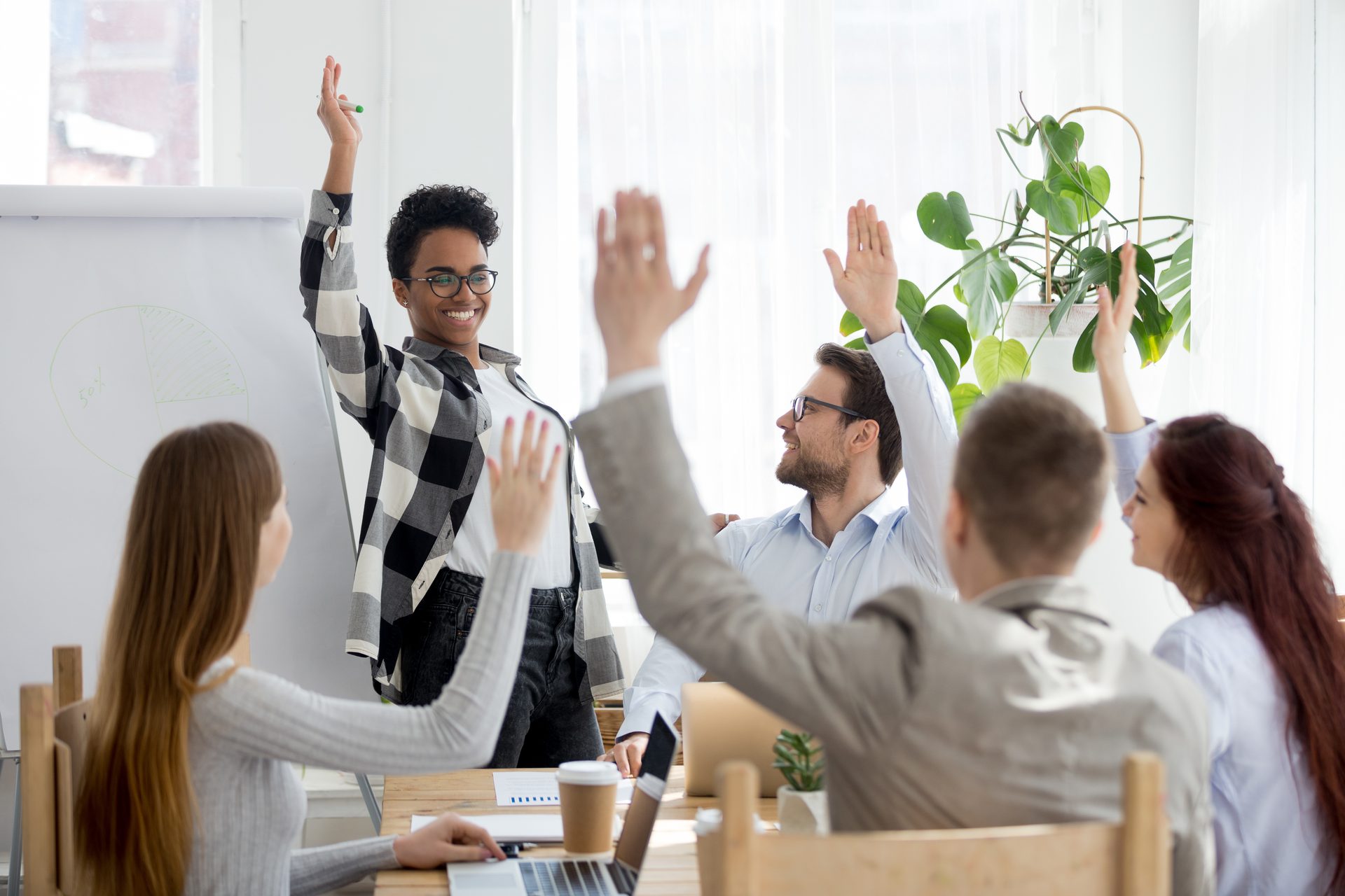 A diverse group raising their hands during a corporate session