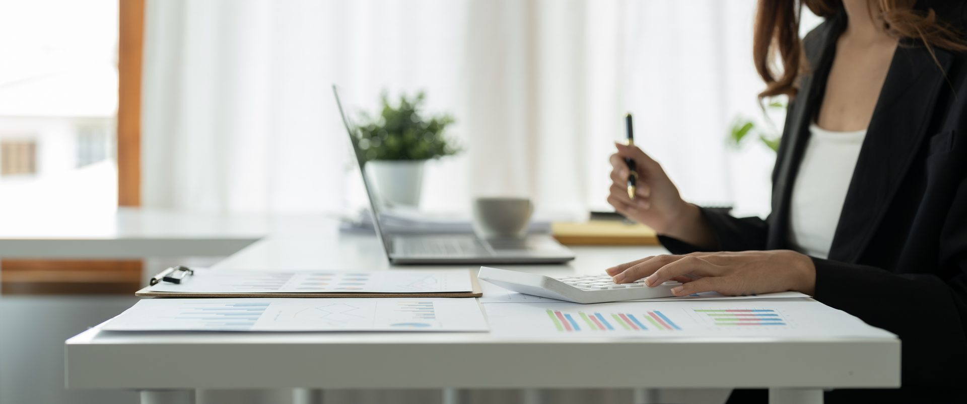 Close-up of hands reconciling a financial report